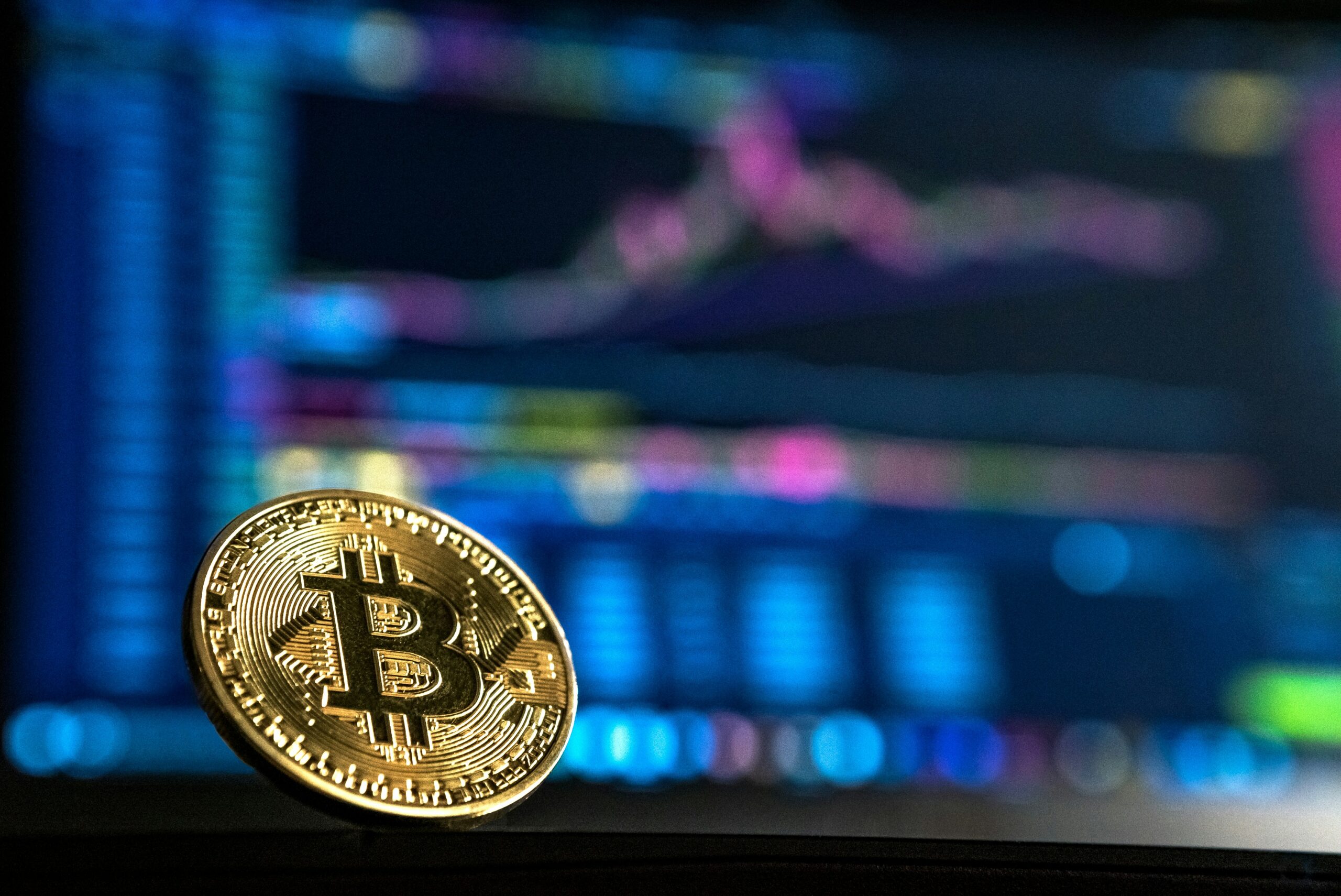 Позолоченная монета Биткоин на фоне динамики акций