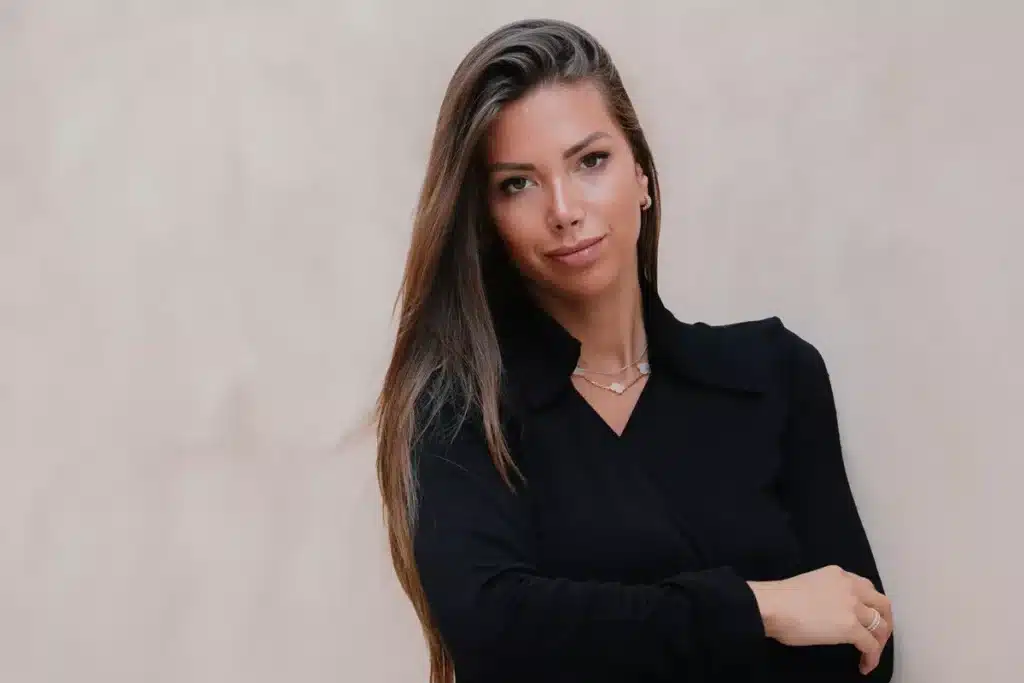 Лаура Вилларс, 28-летняя итало-швейцарская гонщица в чёрном наряде на нейтральном фоне — кандидатки на пост президента FIA (выборы FIA в Ташкенте).