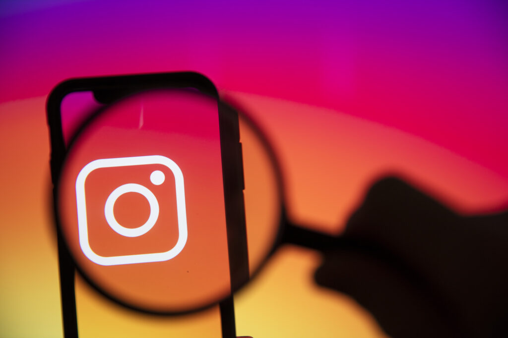 LONDON, UK - June 2020: Instagram logo under a magnifying glass on a smartphone